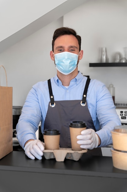 Man with apron preparing food for takeaway