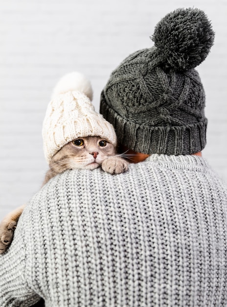 Man with back holding small kitten