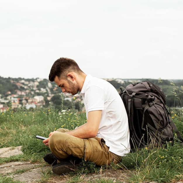 Man with backpack checking mobile