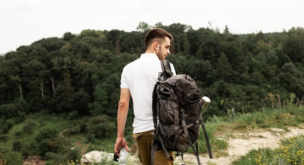 Free photo man with backpack traveling in forest