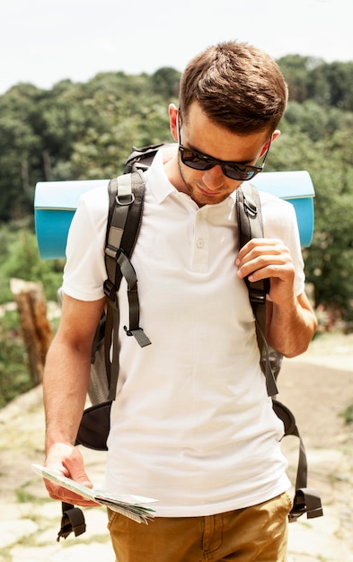 Free photo man with backpack traveling and reading map