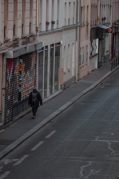 Man with backpack walking on sidewalk