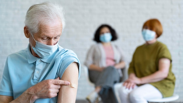 Man with bandage on arm after vaccination