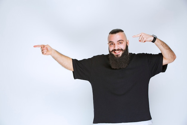 Free Photo man with beard demonstrating his arm muscles and fists.