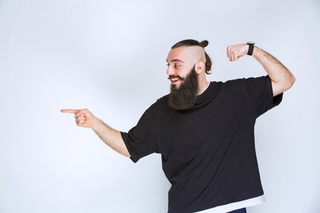 Man with beard demonstrating his arm muscles and fists.