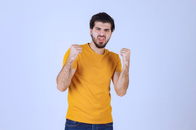 Man with beard demonstrating his fist and arm muscles and feeling powerful