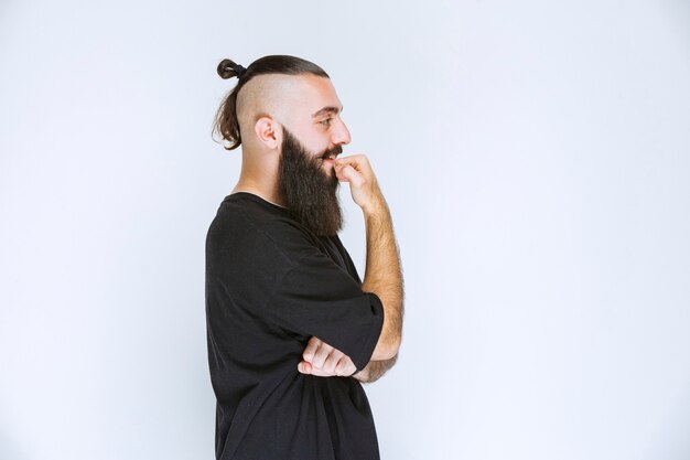 Man with beard looks thoughtful and dreaming.  