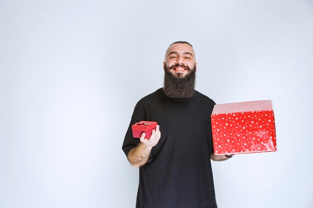 Man with beard offering red gift box    