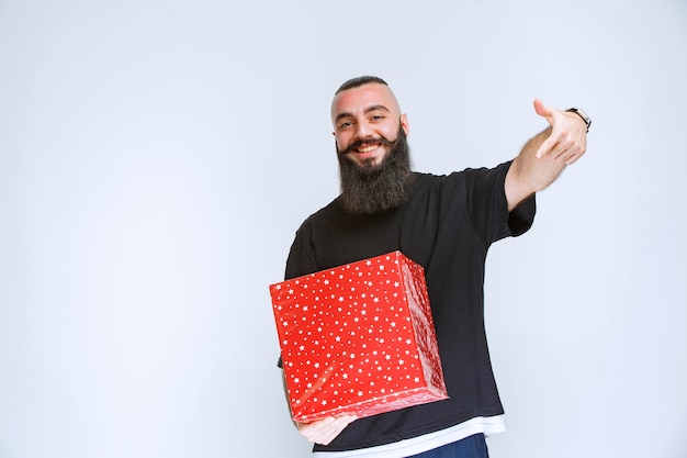 Man with beard showing his red gift box.  