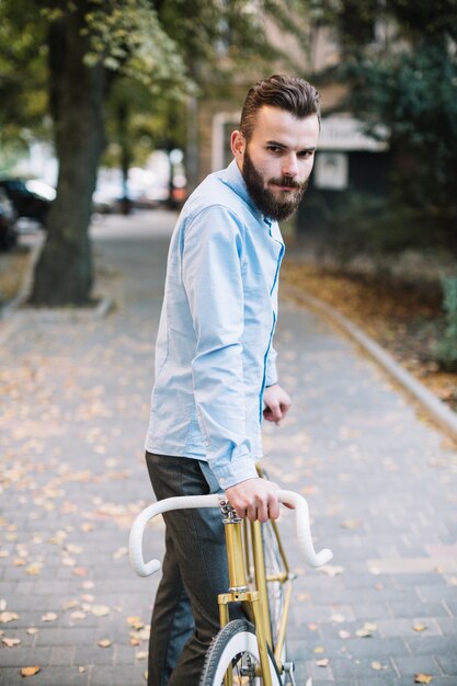 Man with bicycle looking at camera