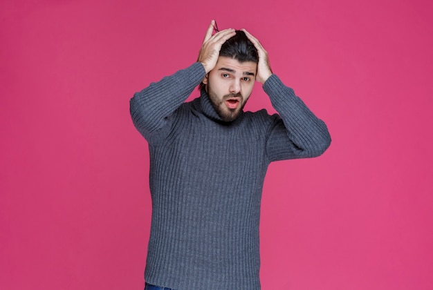 Free Photo man with black beard looks exhausted and bored.