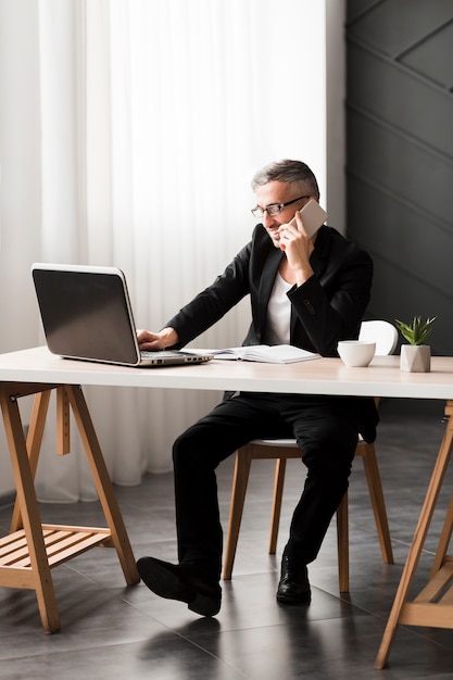 Free photo man with black jacket sitting at the desk