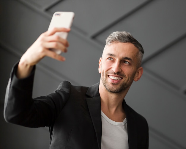 Man with black jacket taking a selfie