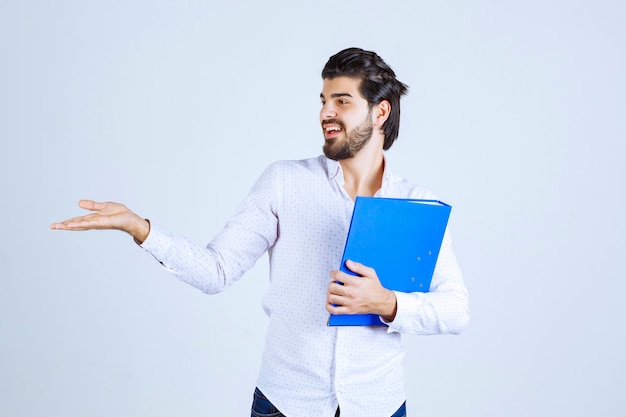 Man with a blue folder introducing his colleague on the left