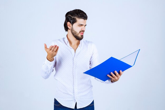 Man with a blue folder looks exhausted and dissatisfied