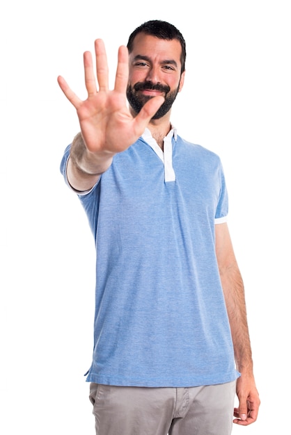 Man with blue shirt counting five