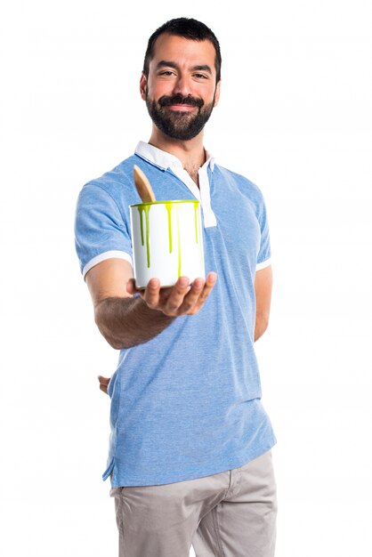 Man with blue shirt holding a paint pot