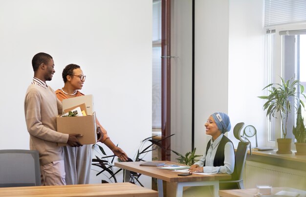 Man with box of belongings being introduced to coworkers at his new job