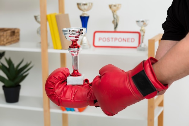 Man with box gloves holding a trophy