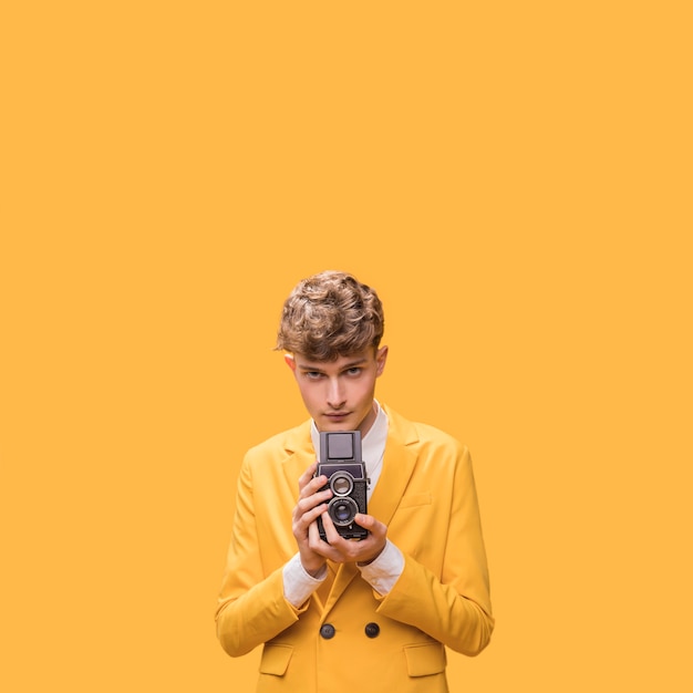 Free photo man with a camcorder in a yellow scene