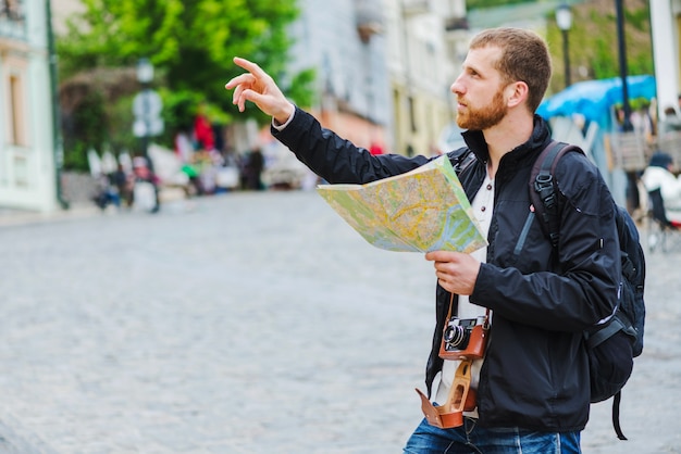 Free Photo man with camera navigating and pointing