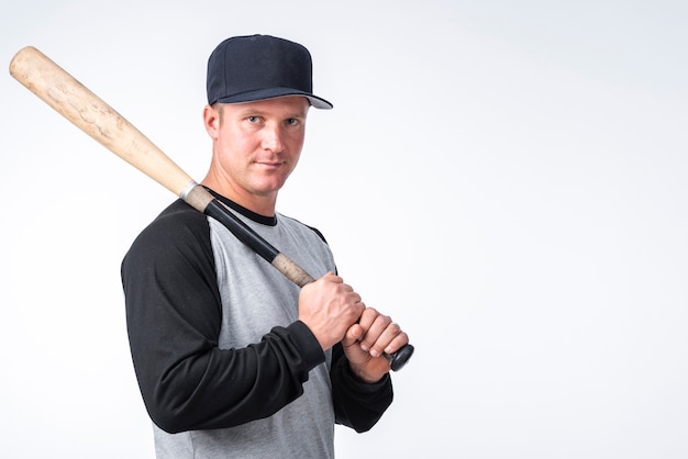 Man with cap posing with baseball bat