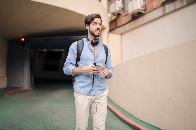 Man with cellphone walking outside building