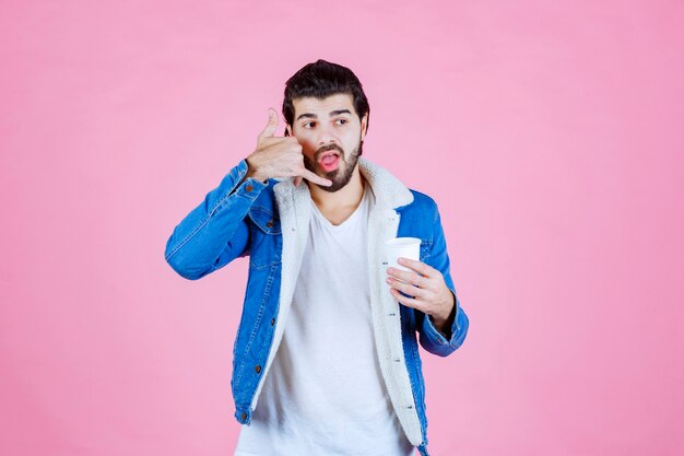 Man with a coffee cup asking for a call