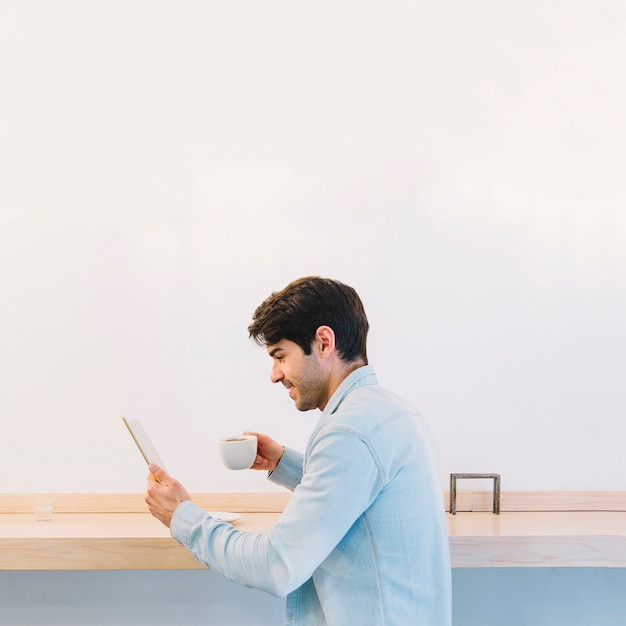 Man with coffee using tablet