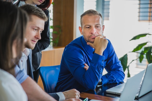 Man with coworkers thinking