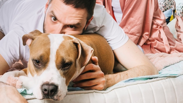 Free Photo man with dog in bed