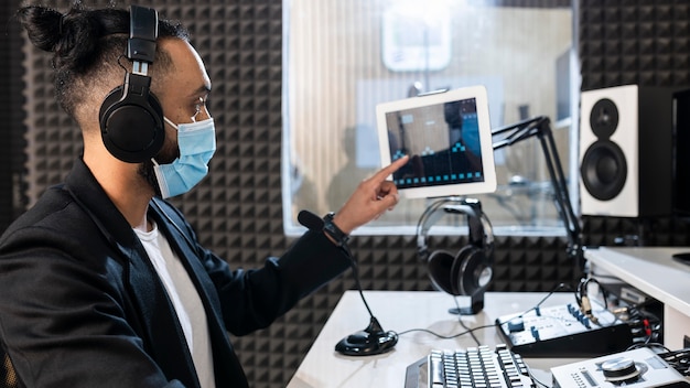 Man with face mask working at a radio station