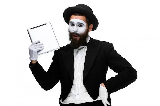 Man with a face mime working on a laptop isolated on a white 