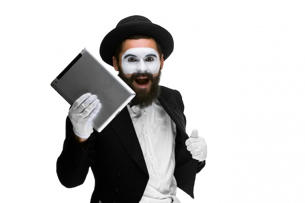 Man with face mime working a laptop isolated on white 