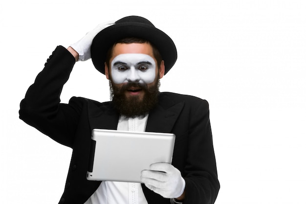 Man with a face mime working on laptop