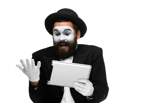 Man with a face mime working on laptop