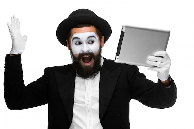 Man with a face mime working on laptop