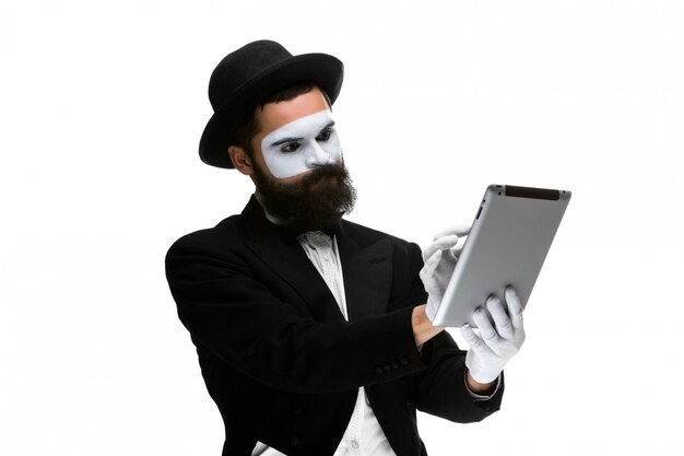 Man with a face mime working ona laptop