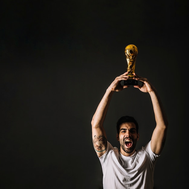 Free photo man with fifa trophy celebrating victory