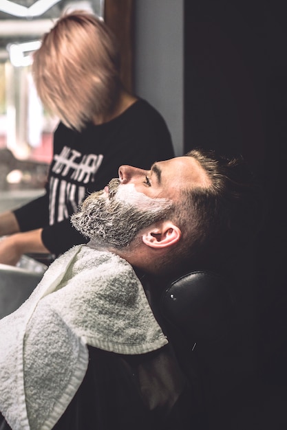 Man with foam on face in barbershop