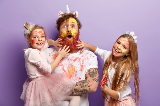 Man with ginger beard and his daughters wearing dirty clothes