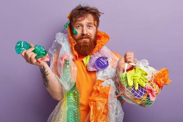 Man with ginger beard holding bags with plastic waste