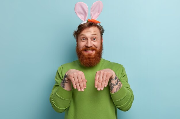 Man with ginger beard wearing colorful clothes and bunny ears