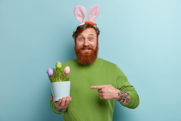 Man with ginger beard wearing colorful clothes and bunny ears