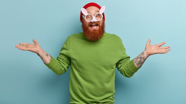 Free photo man with ginger beard wearing colorful clothes and bunny glasses