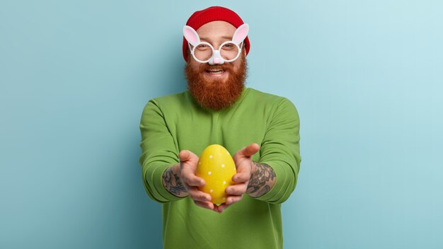 Man with ginger beard wearing colorful clothes and bunny glasses