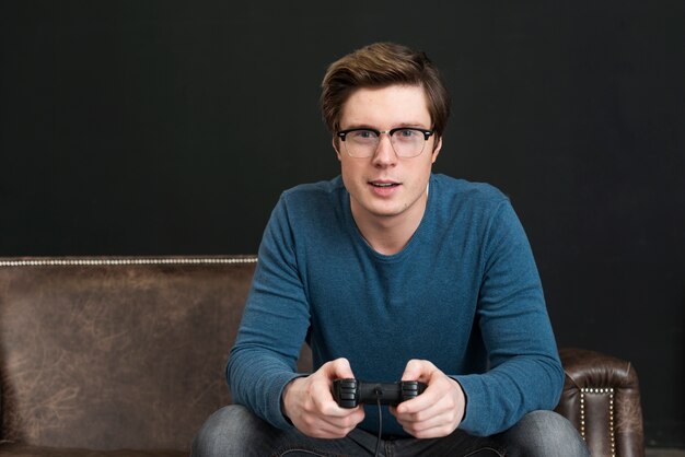 Man with glasses playing with a controller