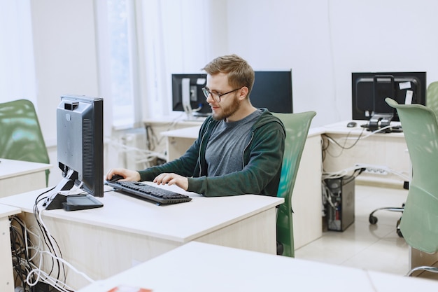 Free Photo man with the glasses. student in computer science class. person uses a computer.