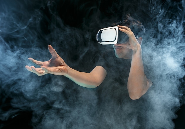 Free photo the man with glasses of virtual reality. future technology concept. black studio smoky