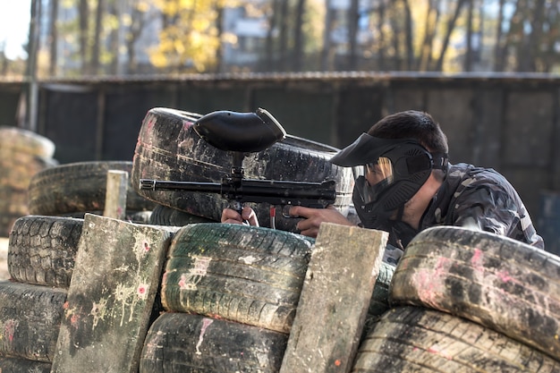 A man with a gun playing paintball.